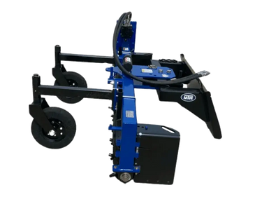 The photo is taken from a low angle, so we can see the underside of the rake and its attachment to the tractor’s three-point hitch.